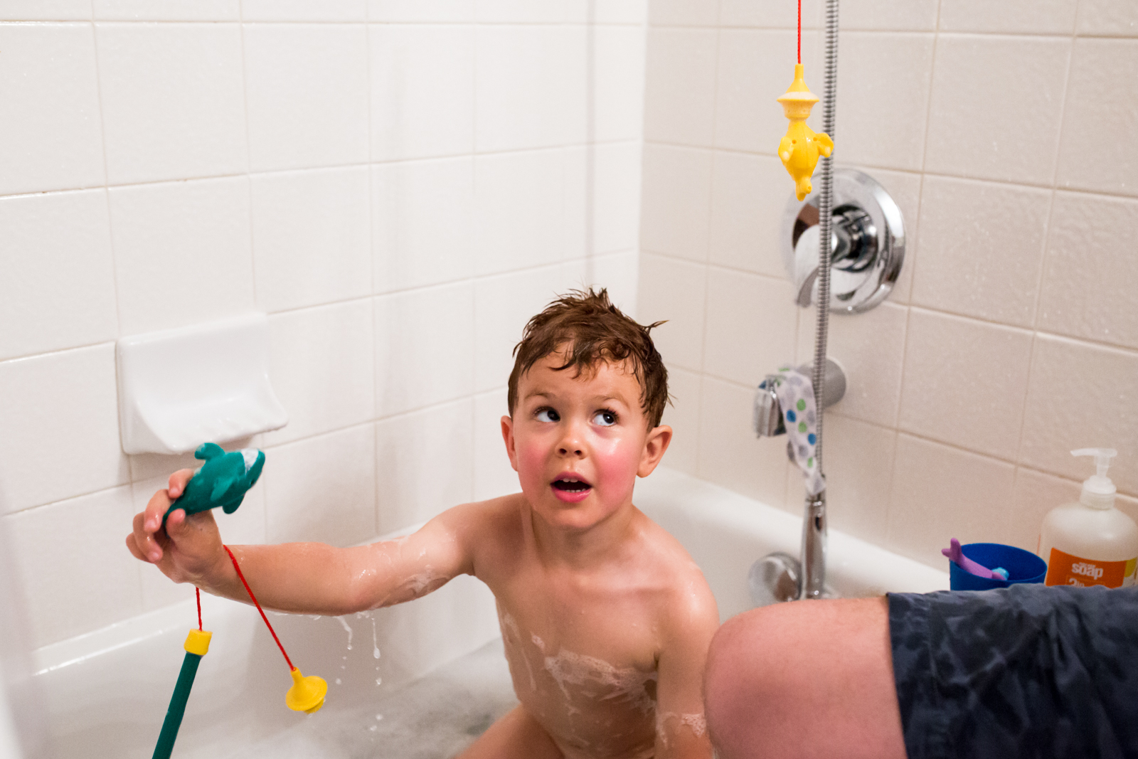 During a Maternity Session, Lawren Rose Photography took a photo of a 4 year old boy playing in the bath with his fishing toys in mckinney texas