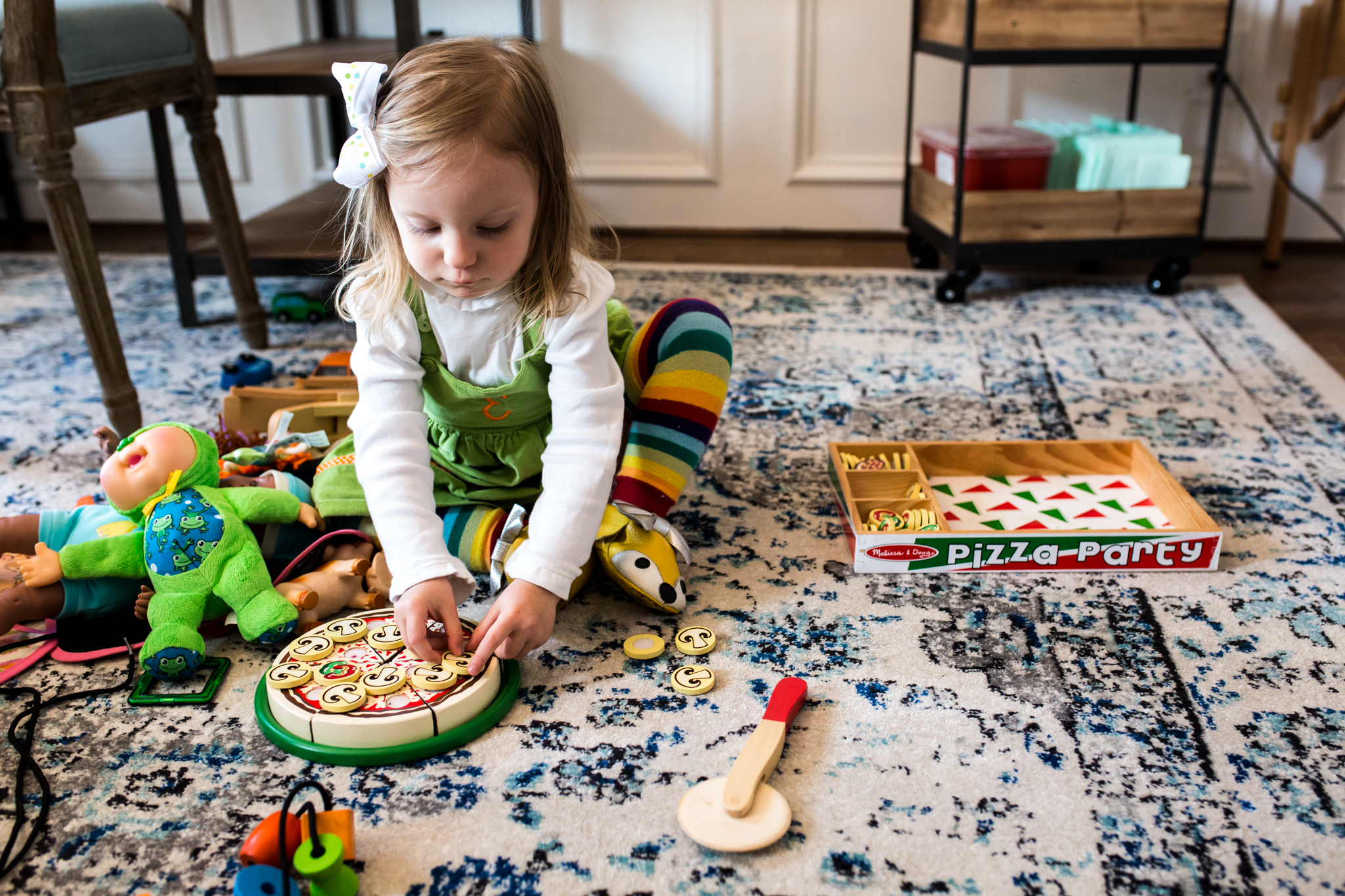 toddler plays with wooden pizza set