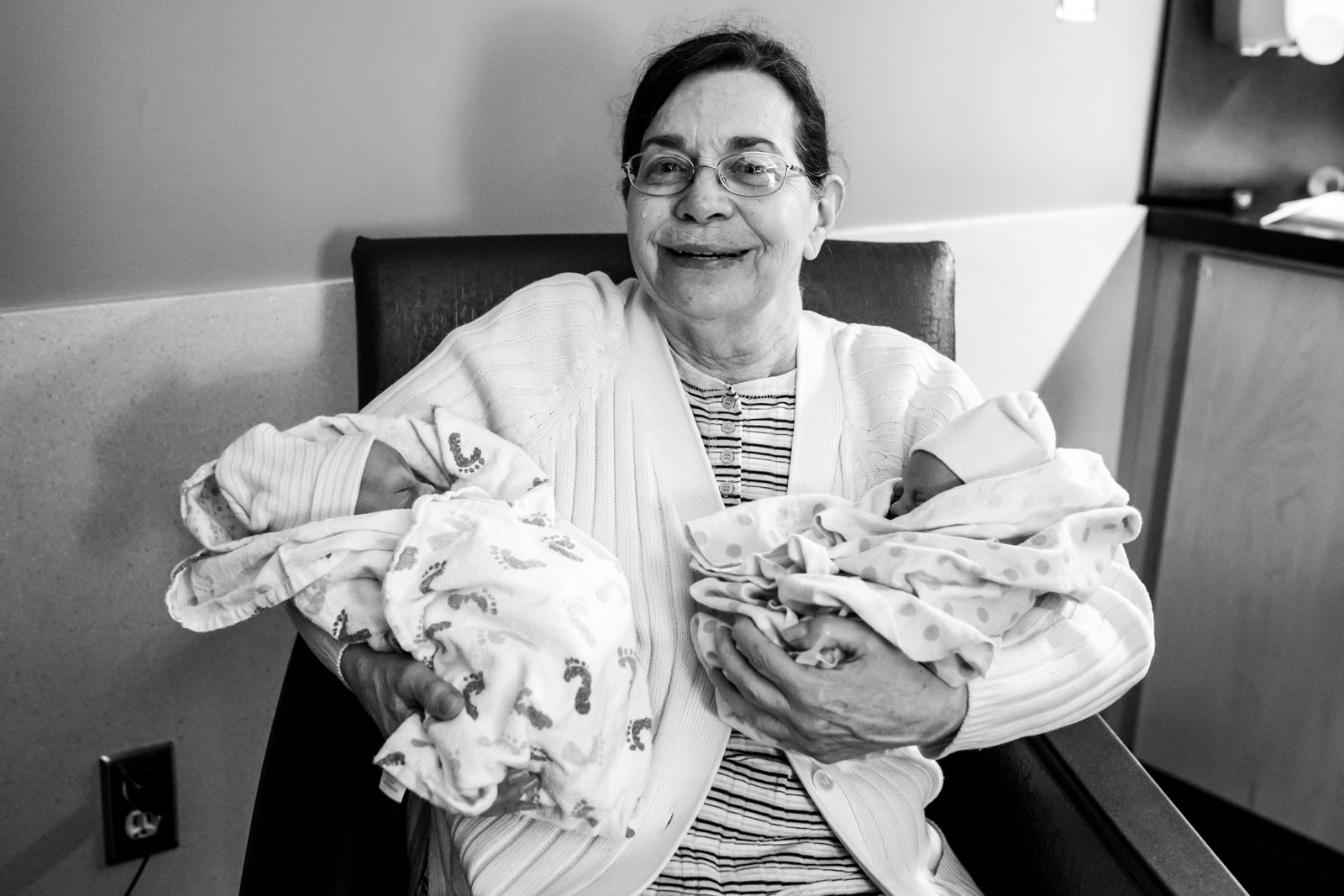 grandma holds her twin grand babies