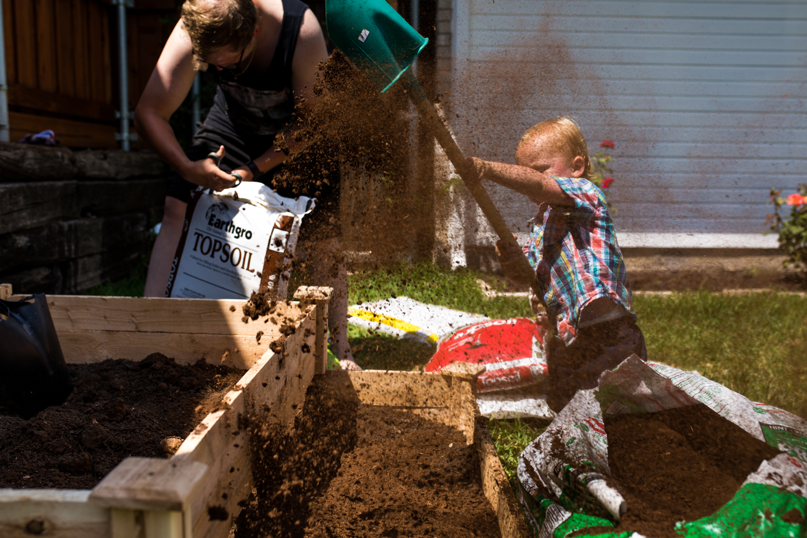 little boy trying to shovel dirt