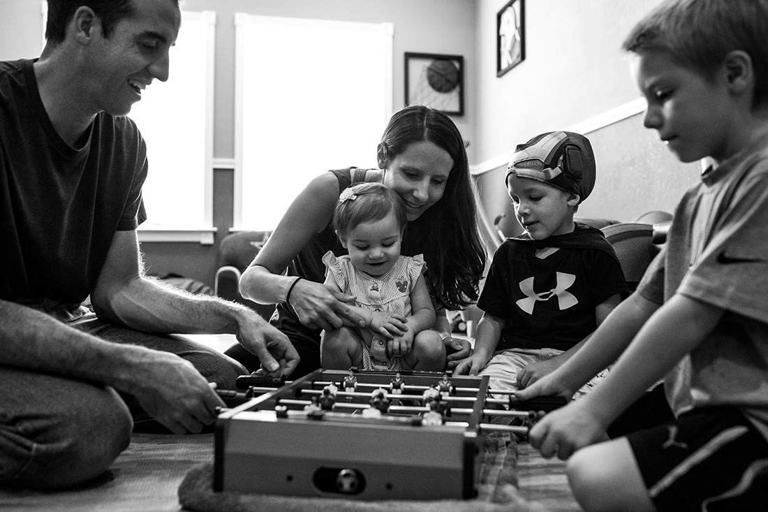 Lawren Rose Photography captures a sweet moment with a family of 5 playing a game together in a Farmers Branch in-home family session