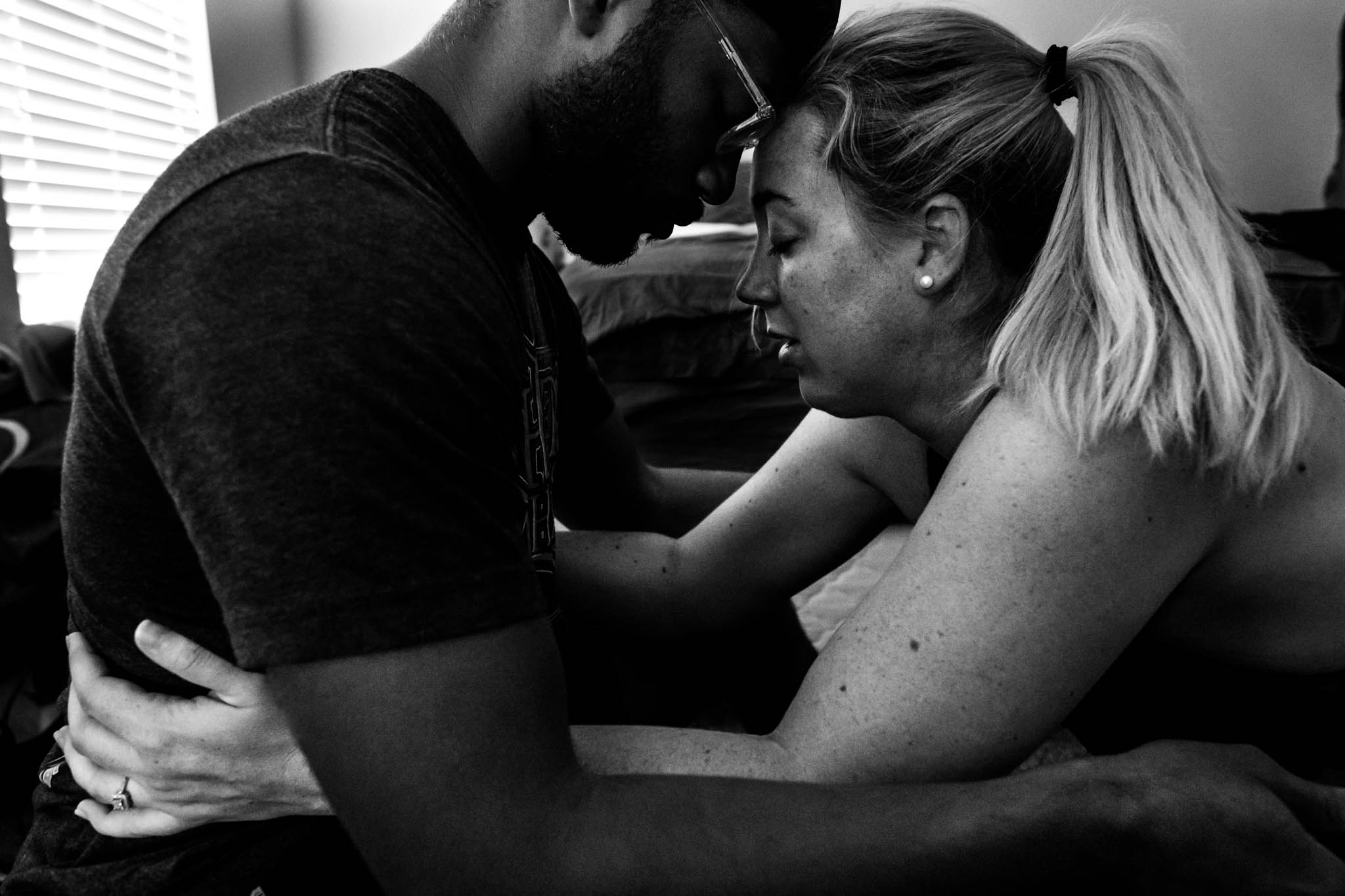 Lawren Rose Photography, a dallas birth photographer, takes a picture of husband and wife being intimate during labor in their home