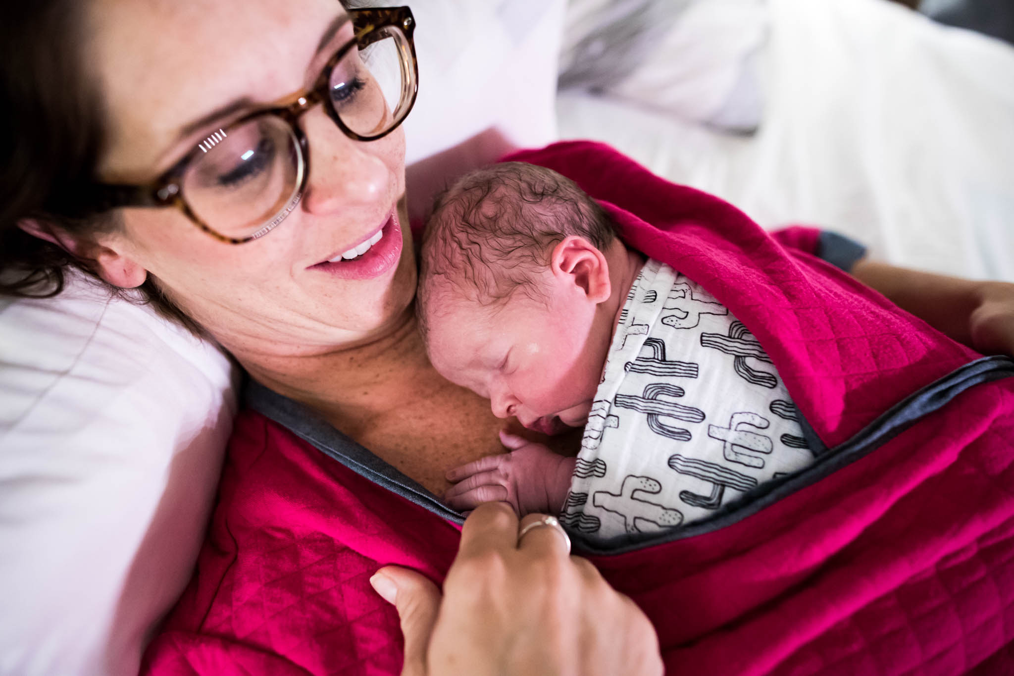 Lawren Rose Photography takes an image of a Mom holding and cuddling onto her brand new son born at home just hours old